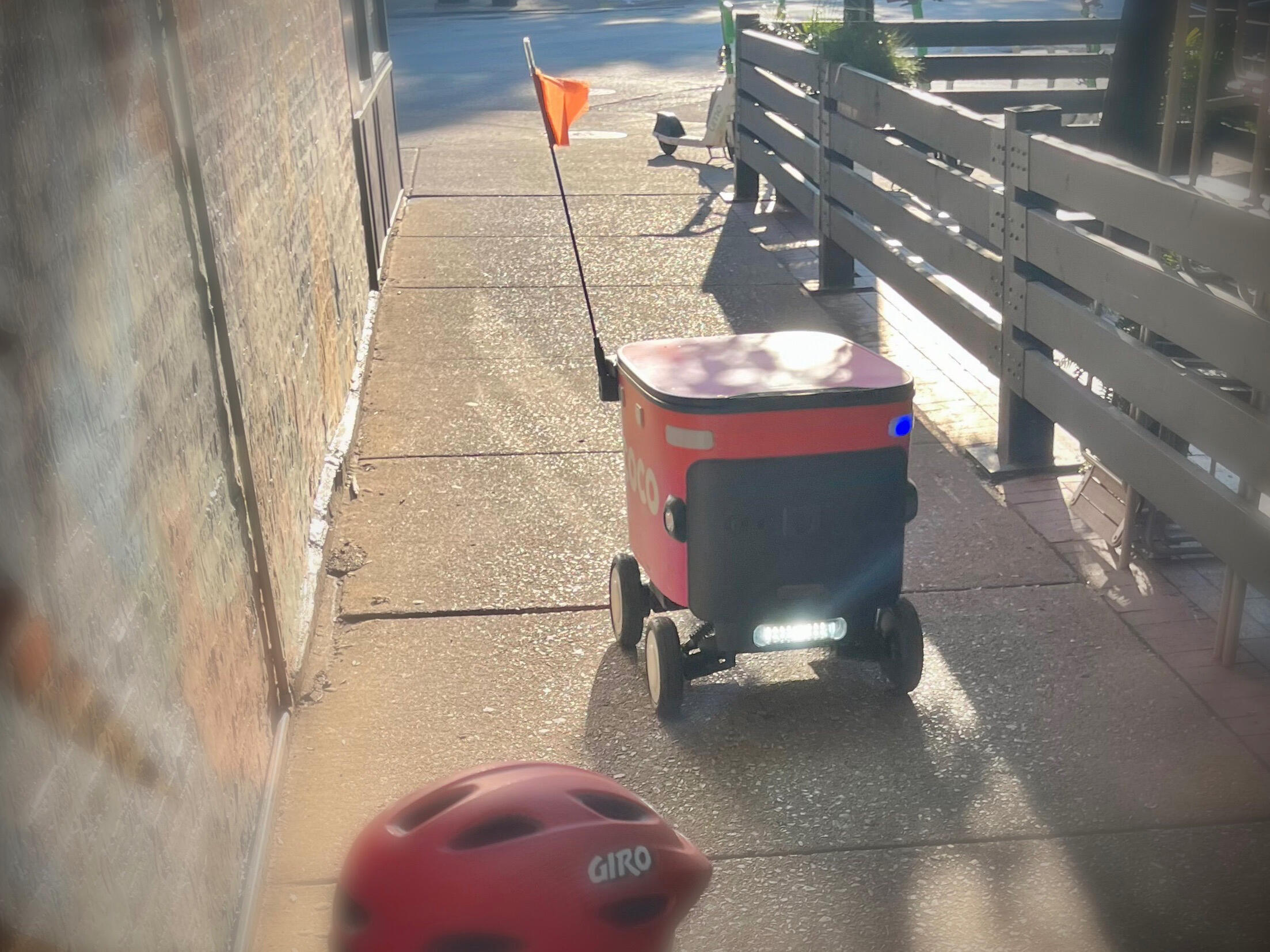 Delivery robot traveling on Chicago sidewalk toward a child